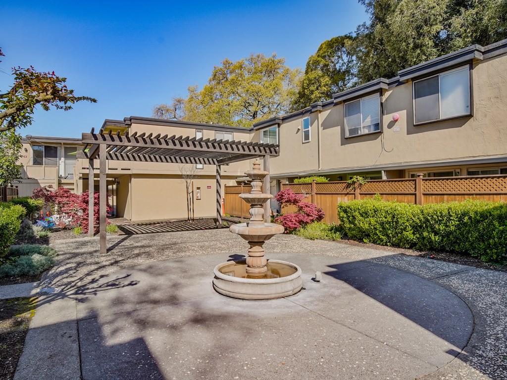 a fountain in the middle of a driveway in front of a house
