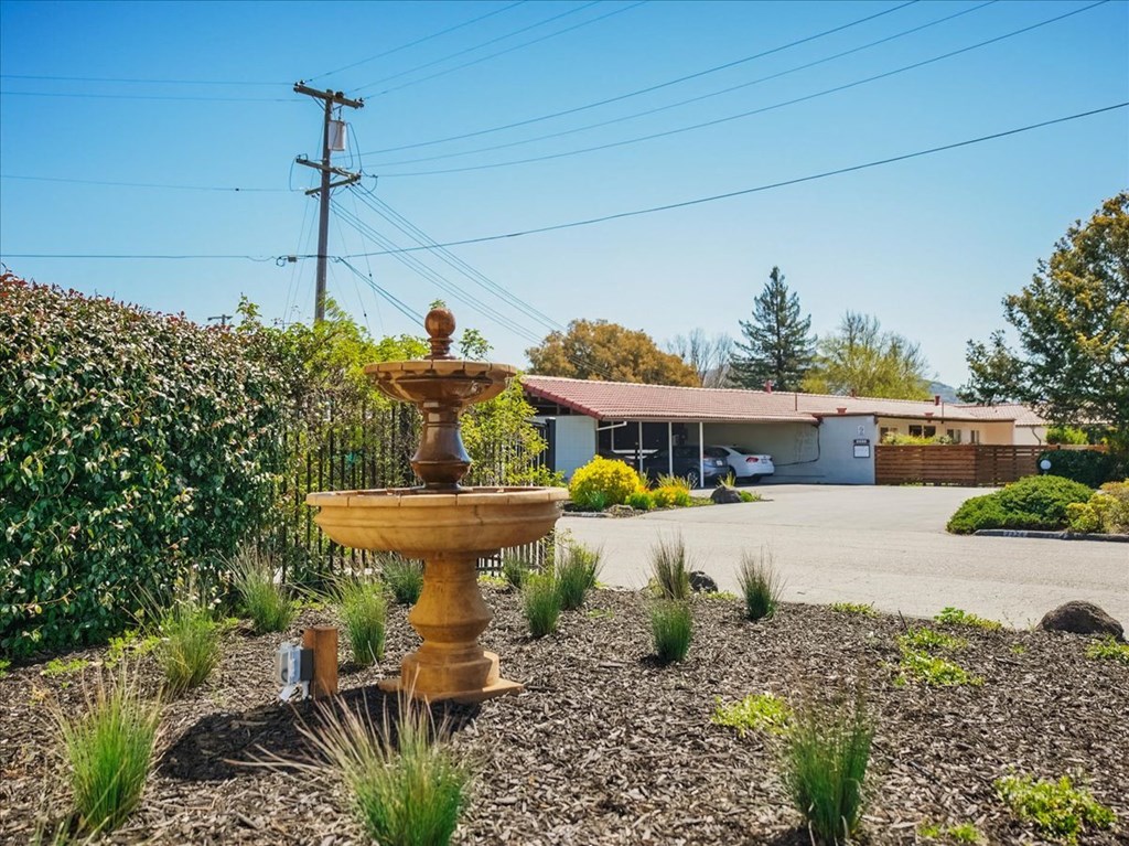 a fountain in a driveway with a house in the background