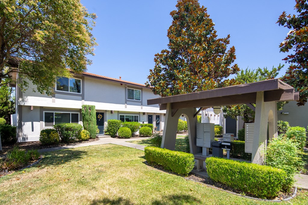 a white building with a porch and a lawn