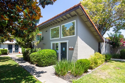 the front of a house with a sidewalk in front of it