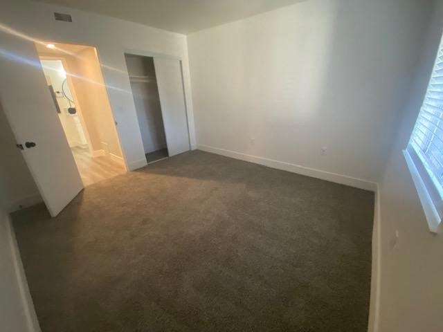 an empty room with a large window and a door