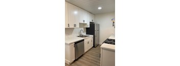 a kitchen with white cabinets and a black refrigerator