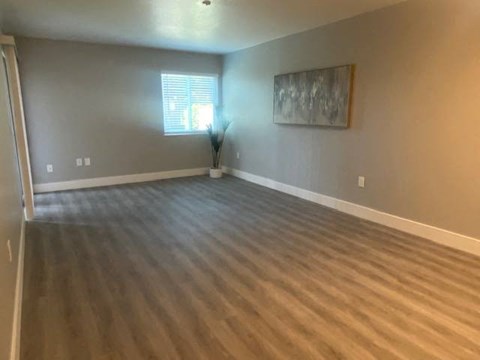 a living room with a wooden floor and a window