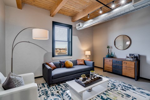 A living room with a grey couch and a white coffee table.