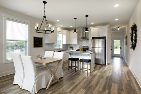 A modern kitchen with a wooden table and chairs.