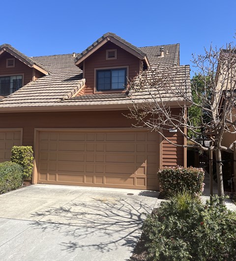 A brown house with a tan garage door.