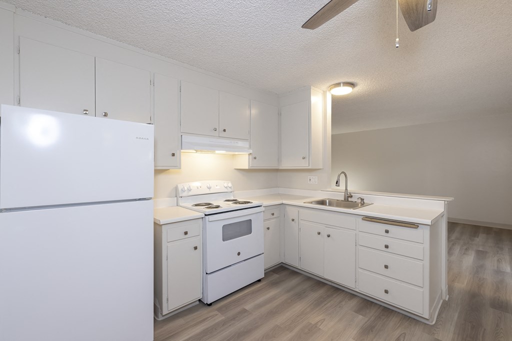 a white kitchen with white appliances and white cabinets