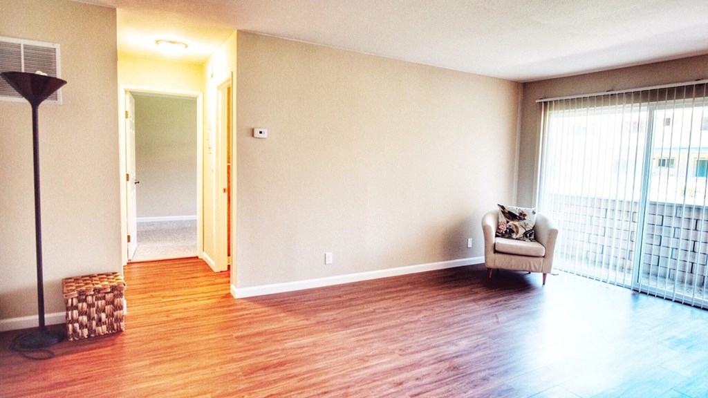 an empty living room with a chair and a window