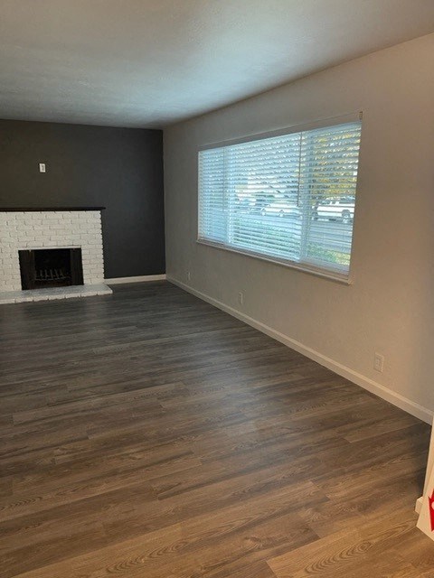 an empty living room with a fireplace and a window