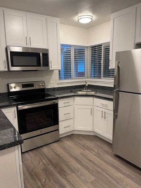 a kitchen with white cabinets and stainless steel appliances