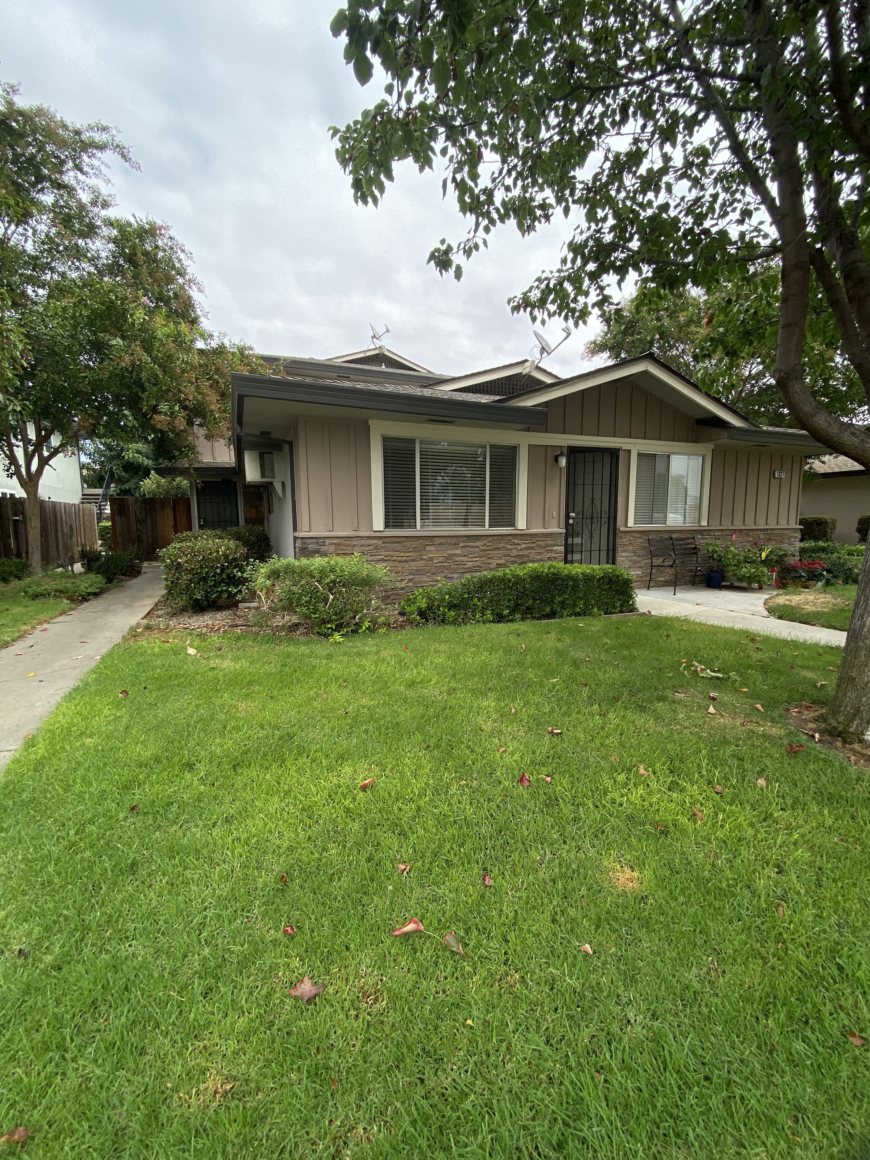 a house with a yard and sidewalk in front of it