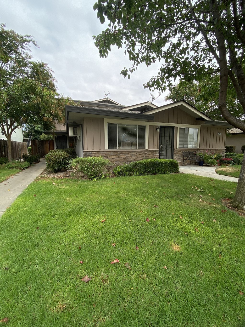 a house with a yard and sidewalk in front of it
