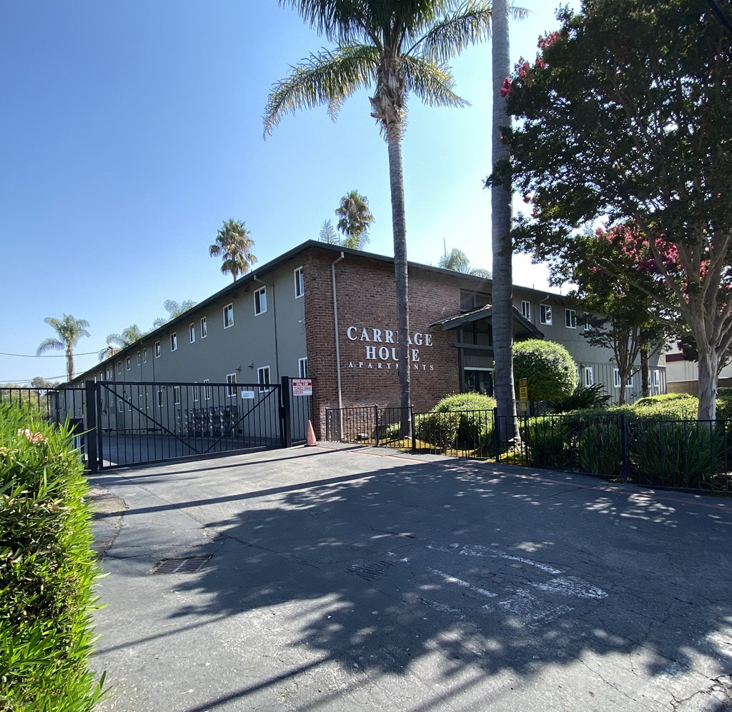 a building with palm trees and a road in front of it