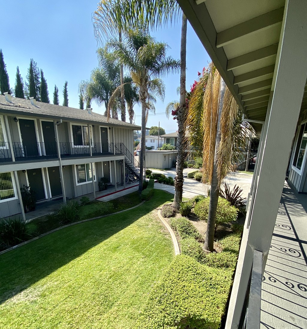 the view of the courtyard from the balcony of a condo building
