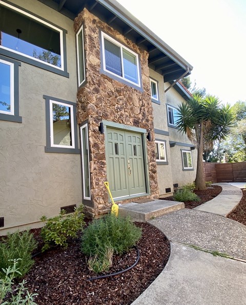 A house with a green door and a stone pillar.