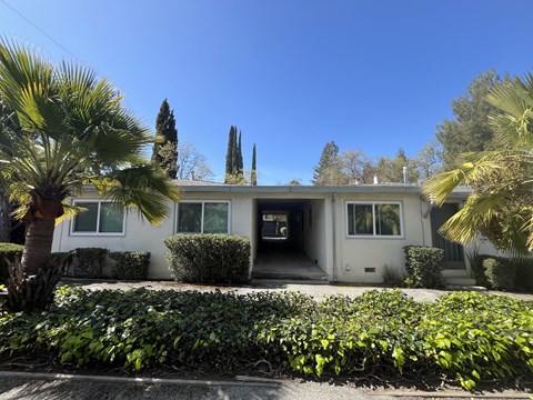 A house with a white exterior and a green lawn in front.
