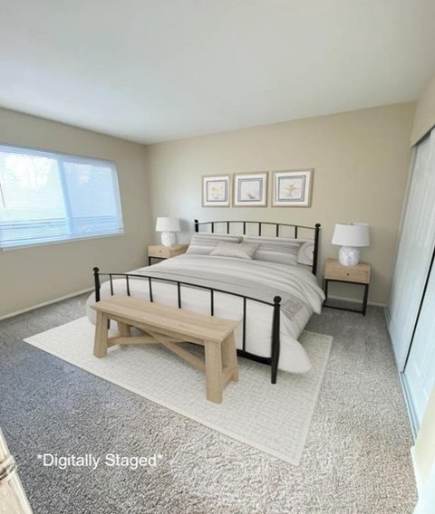 A bedroom with a bed, nightstands, and a bench.