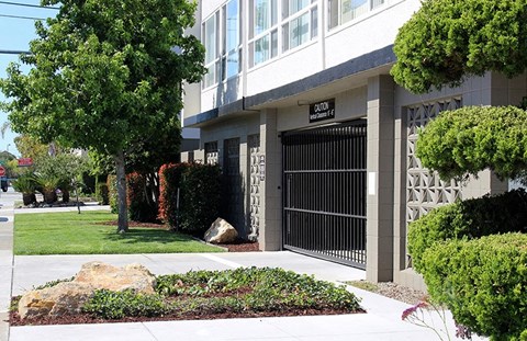 a building with a gate in front of a sidewalk