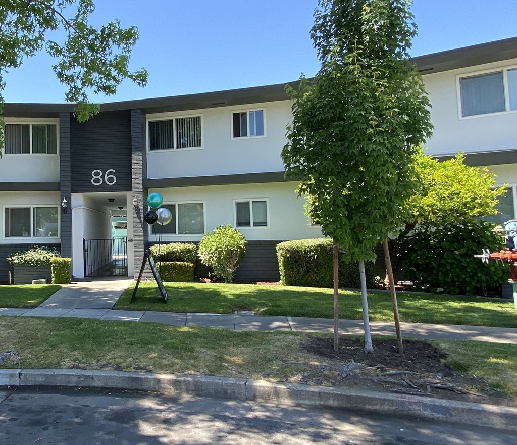 an apartment building with a yard and trees in front of it. Intergritas Apartments 86 Renato Court  Redwood City, CA 94061 (650) 465-2410 Prodesse Property Group