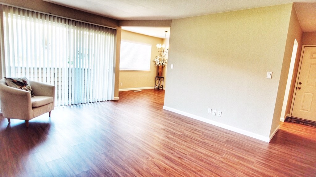 an empty living room with a hard wood floor