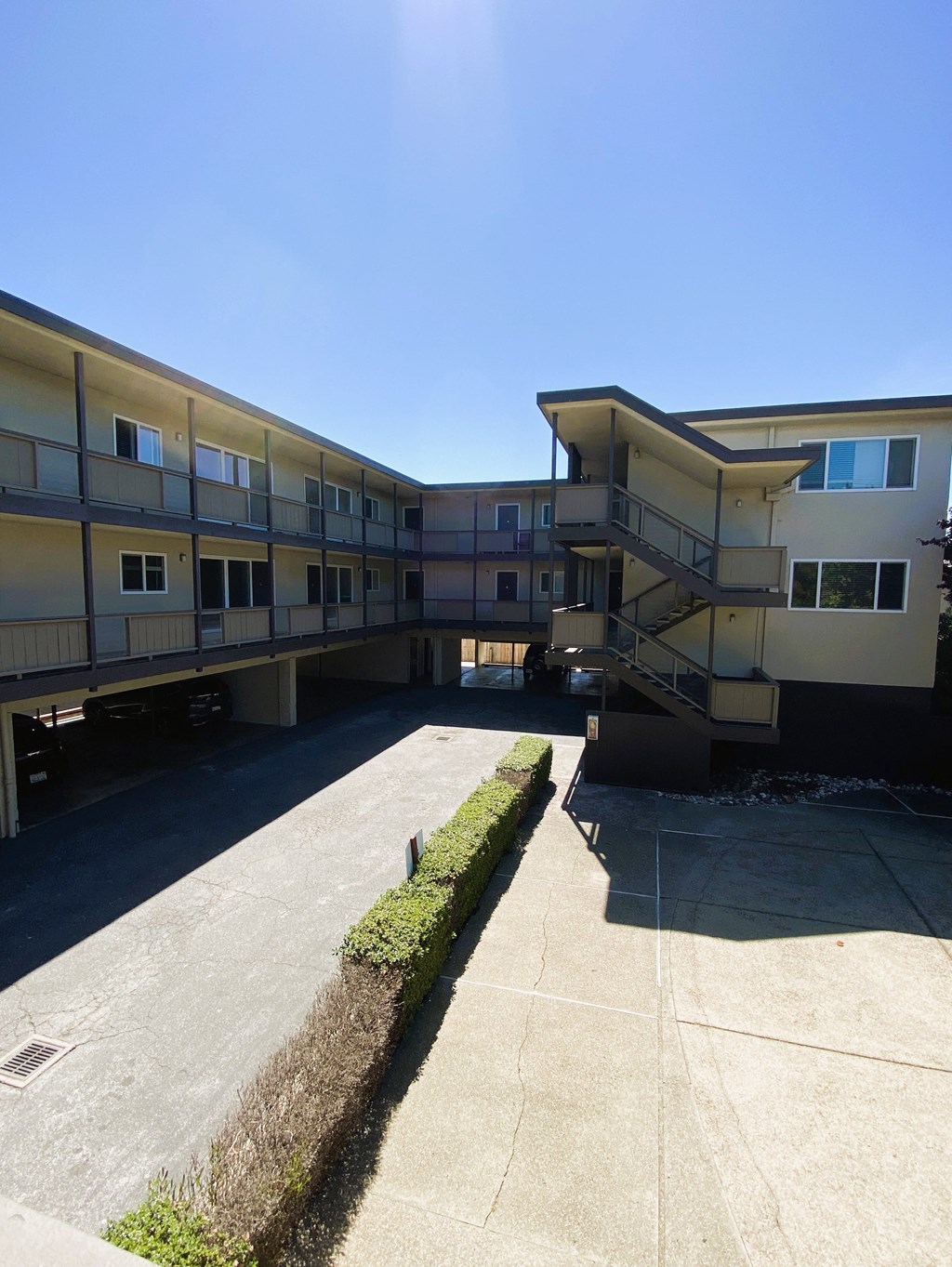 an exterior view of an apartment building with a parking lot