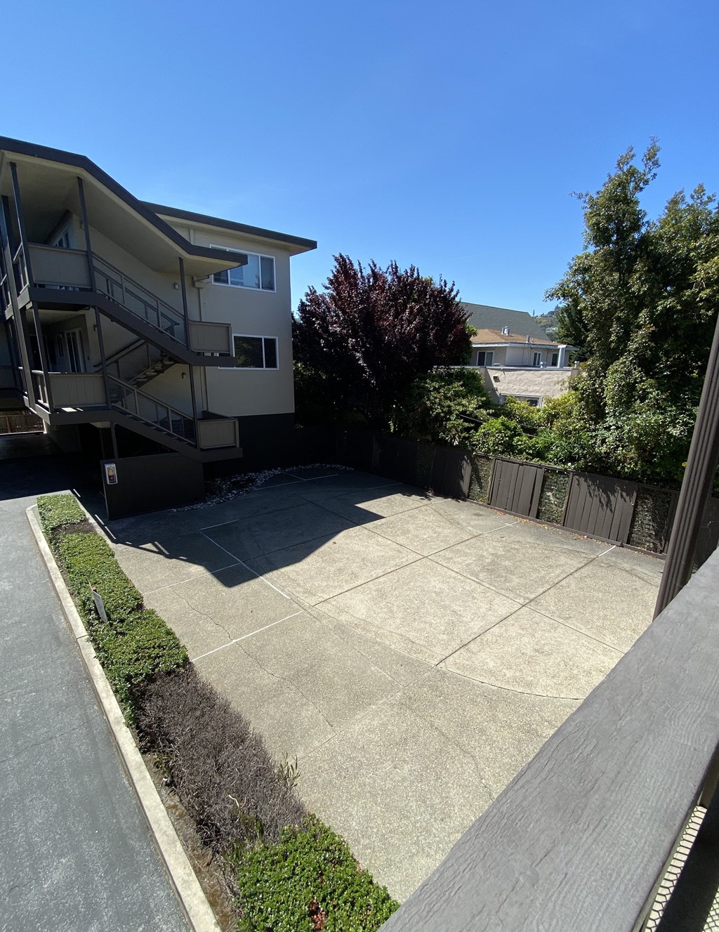 a view of the backyard of an apartment building with a driveway