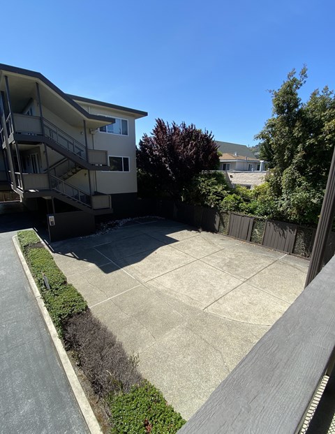 a view of the backyard of an apartment building with a driveway