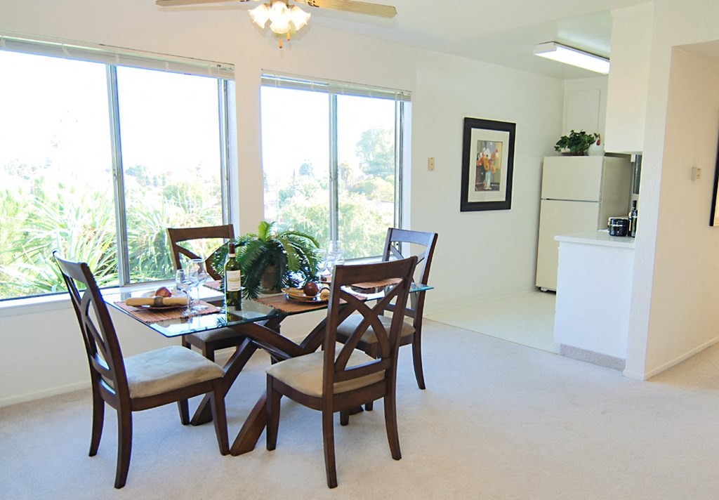a four seat table dining set located inside of a unit looking into the white kitchen and beige carpet inside the unit Prodesse Property Group 1211 Garbo Way  San Jose, CA 95117