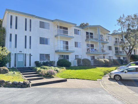 an apartment building on a street with cars in front of it
