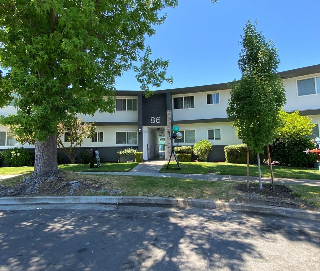 a large apartment building with a tree in front of it Intergritas Apartments 86 Renato Court  Redwood City, CA 94061 (650) 465-2410 Prodesse Property Group