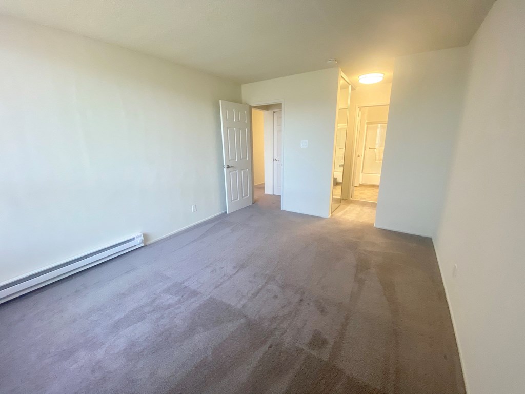 an empty living room with wood floors and white walls