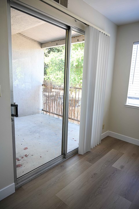 a living room with a sliding glass door to a balcony