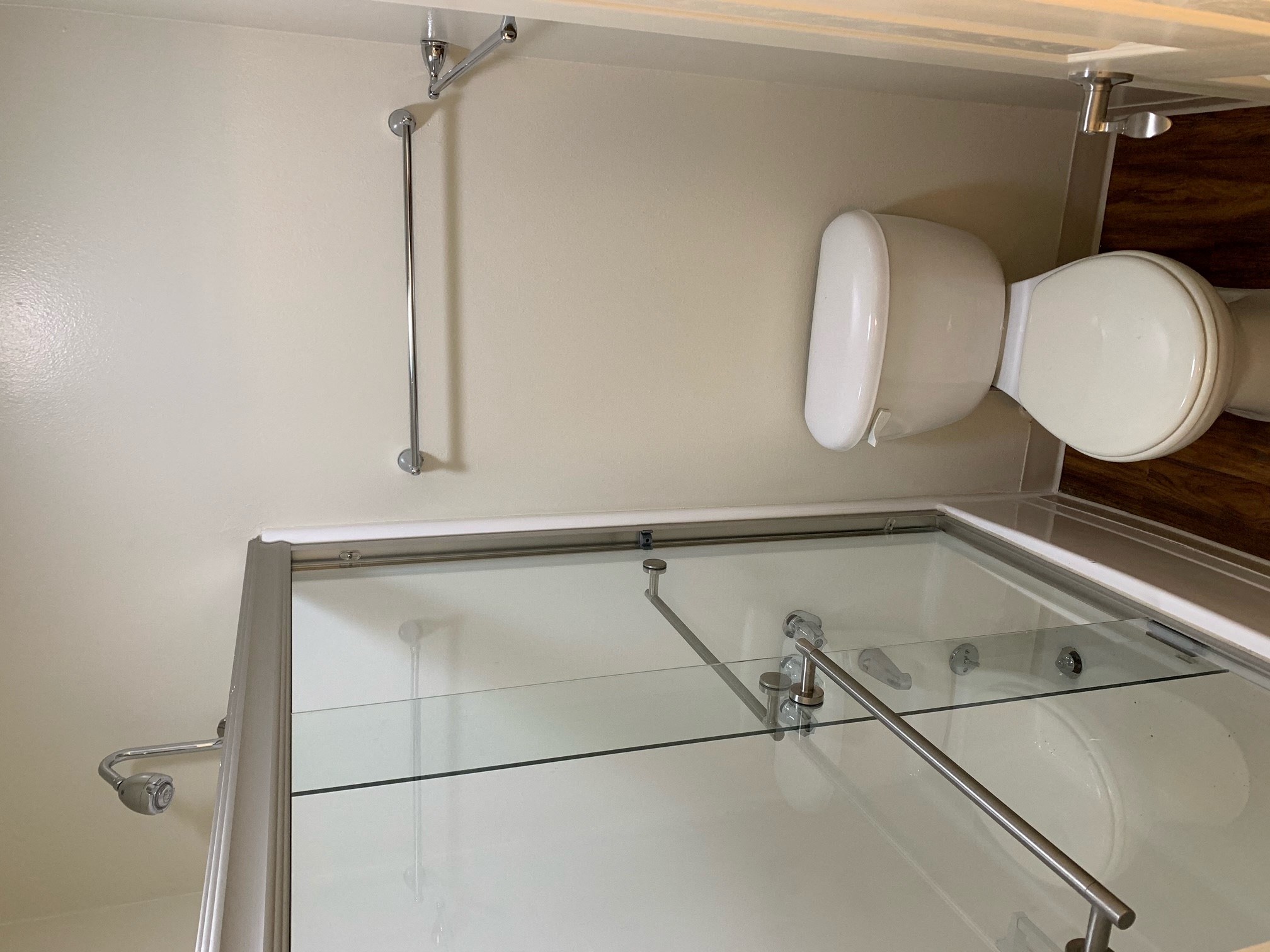 a bathroom with a glass shower and a toilet and a sink