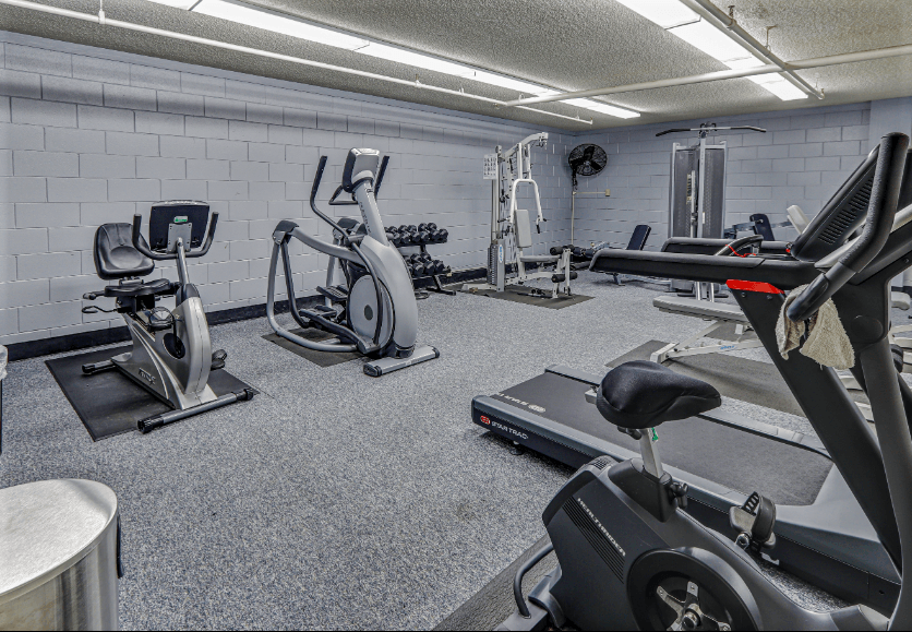 a gym with cardio equipment and weights in a building