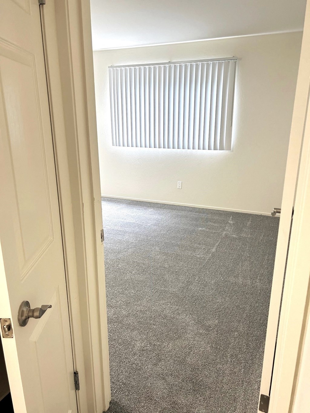 a room with a carpeted floor and a window