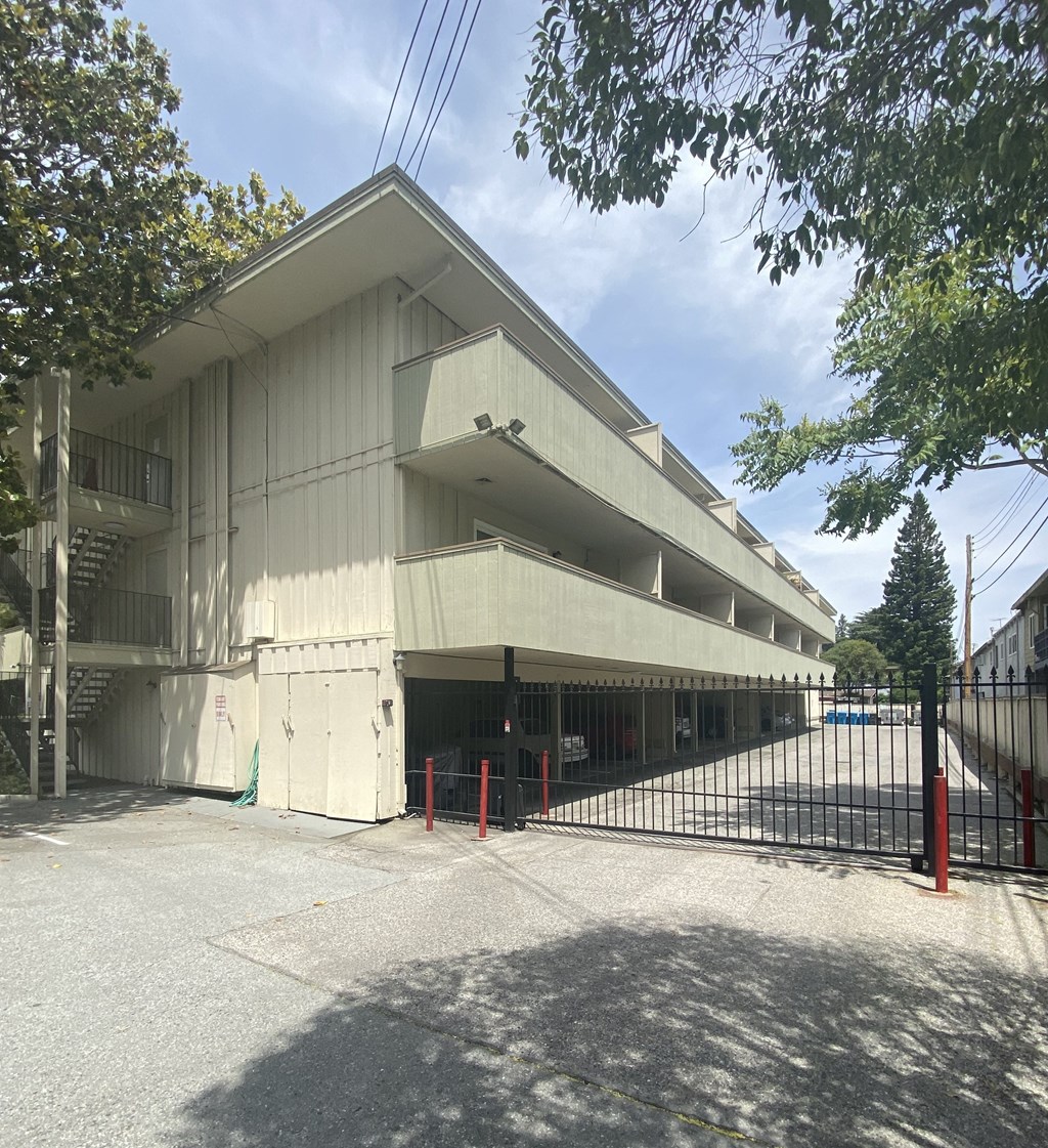 a large white building with a fence and a gate