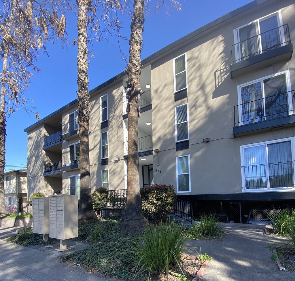 an apartment building with two palm trees in front of it