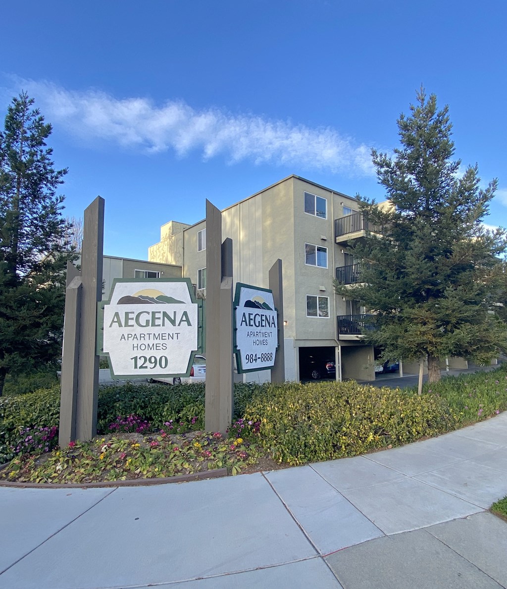 an apartment building with two signs in front of it