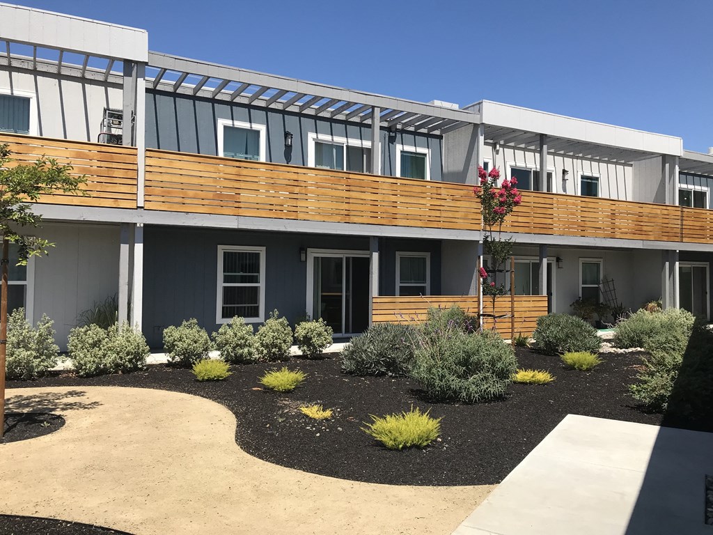 a view of the front of a building with a garden in front of it