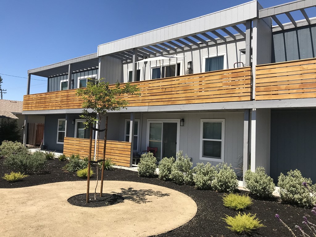a view of the front of a building with a tree in front of it