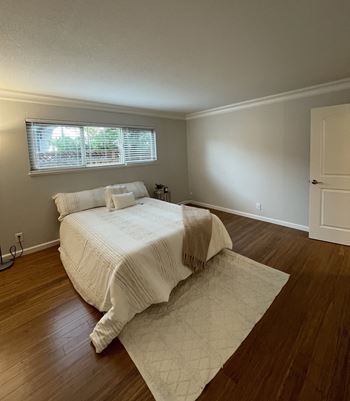 an empty bedroom with a bed and a window