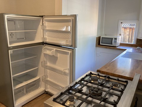 A white refrigerator with its door open in a kitchen.
