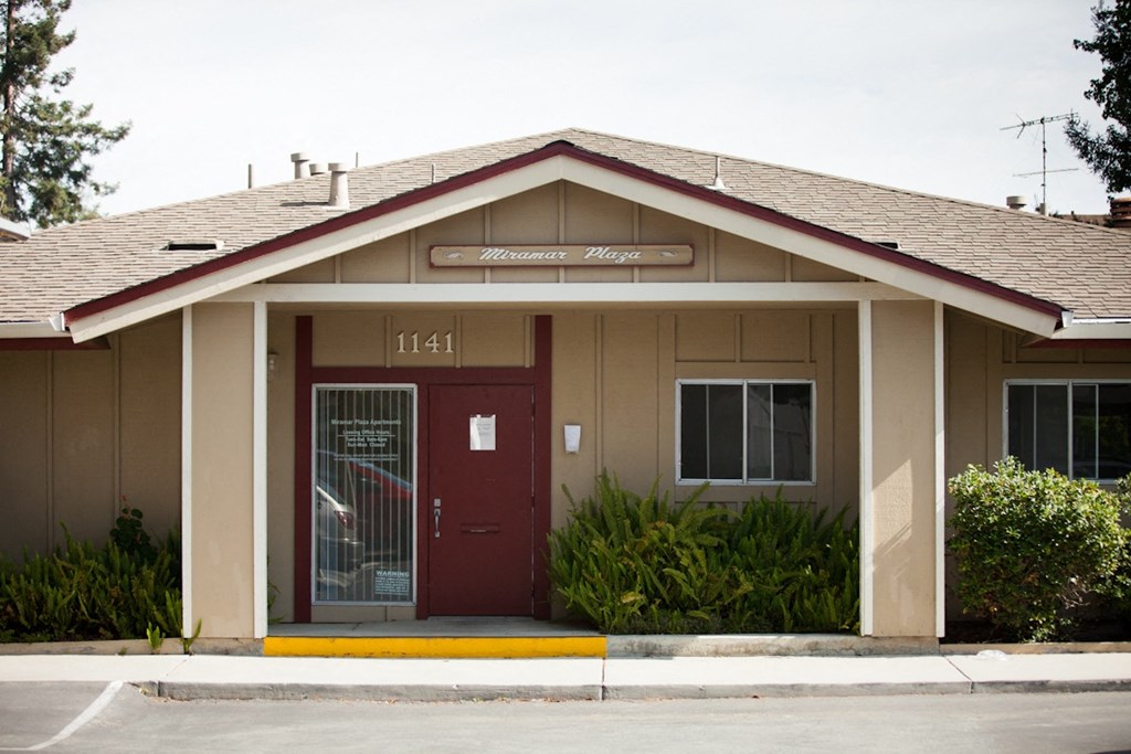 a brown building with a red door