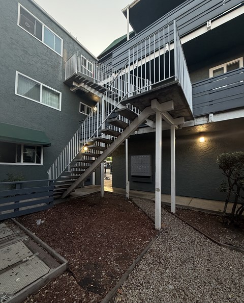 A staircase with a metal railing leads up to a building.
