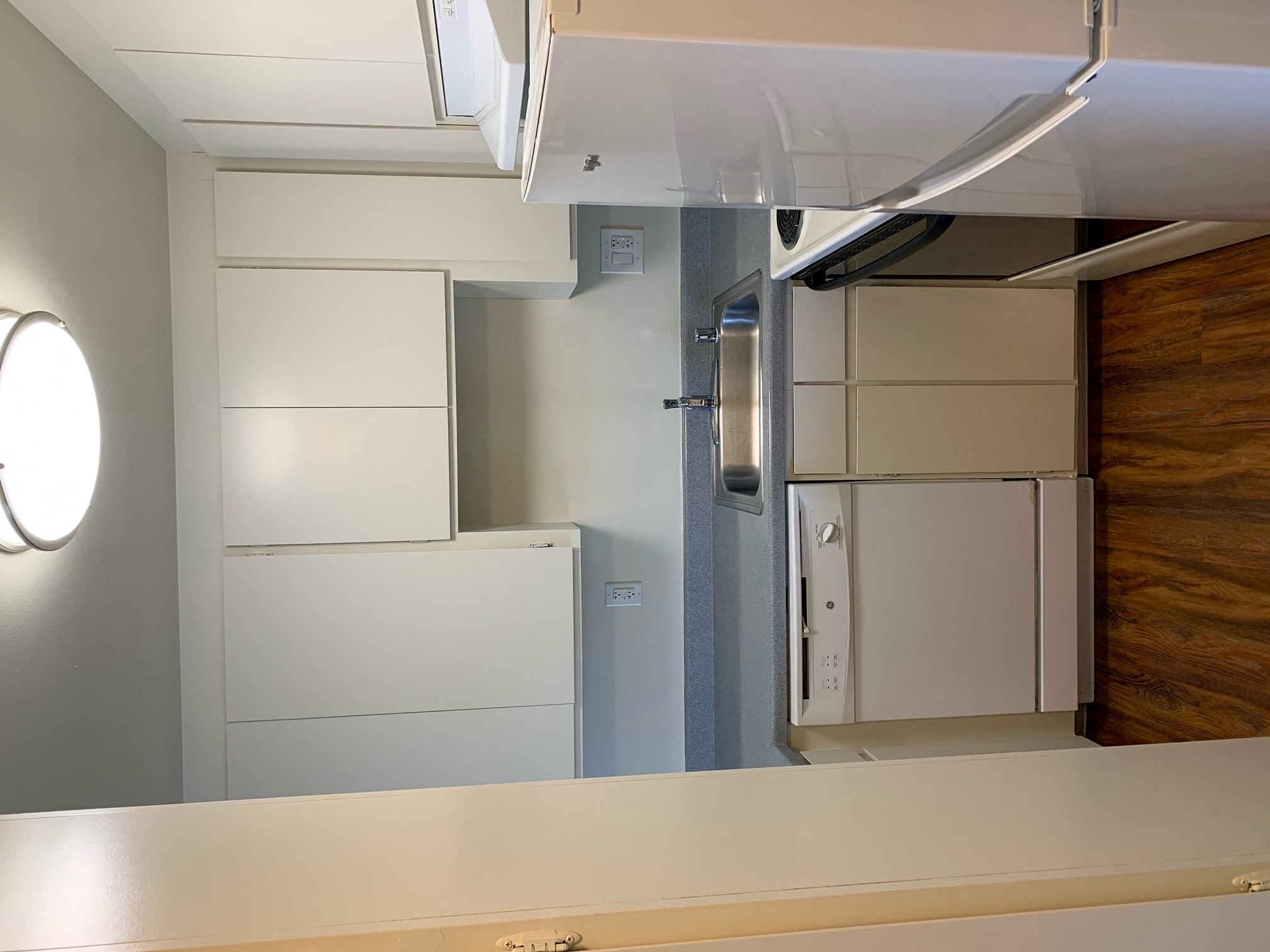 a small kitchen with a white counter top and a refrigerator