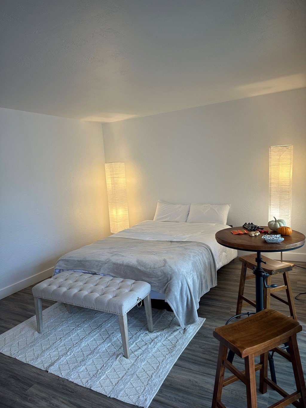 a bedroom with a bed and a table with a stool