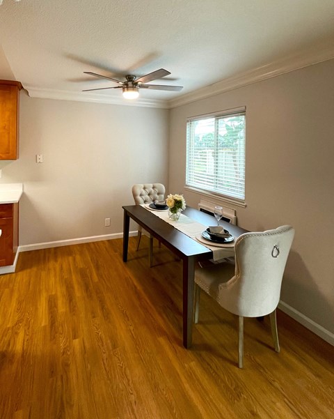 a dining room with a table and chairs and a ceiling fan