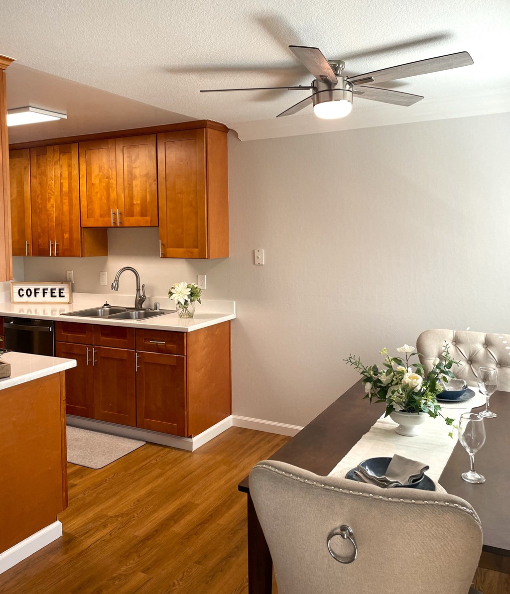 a kitchen with a table and a ceiling fan
