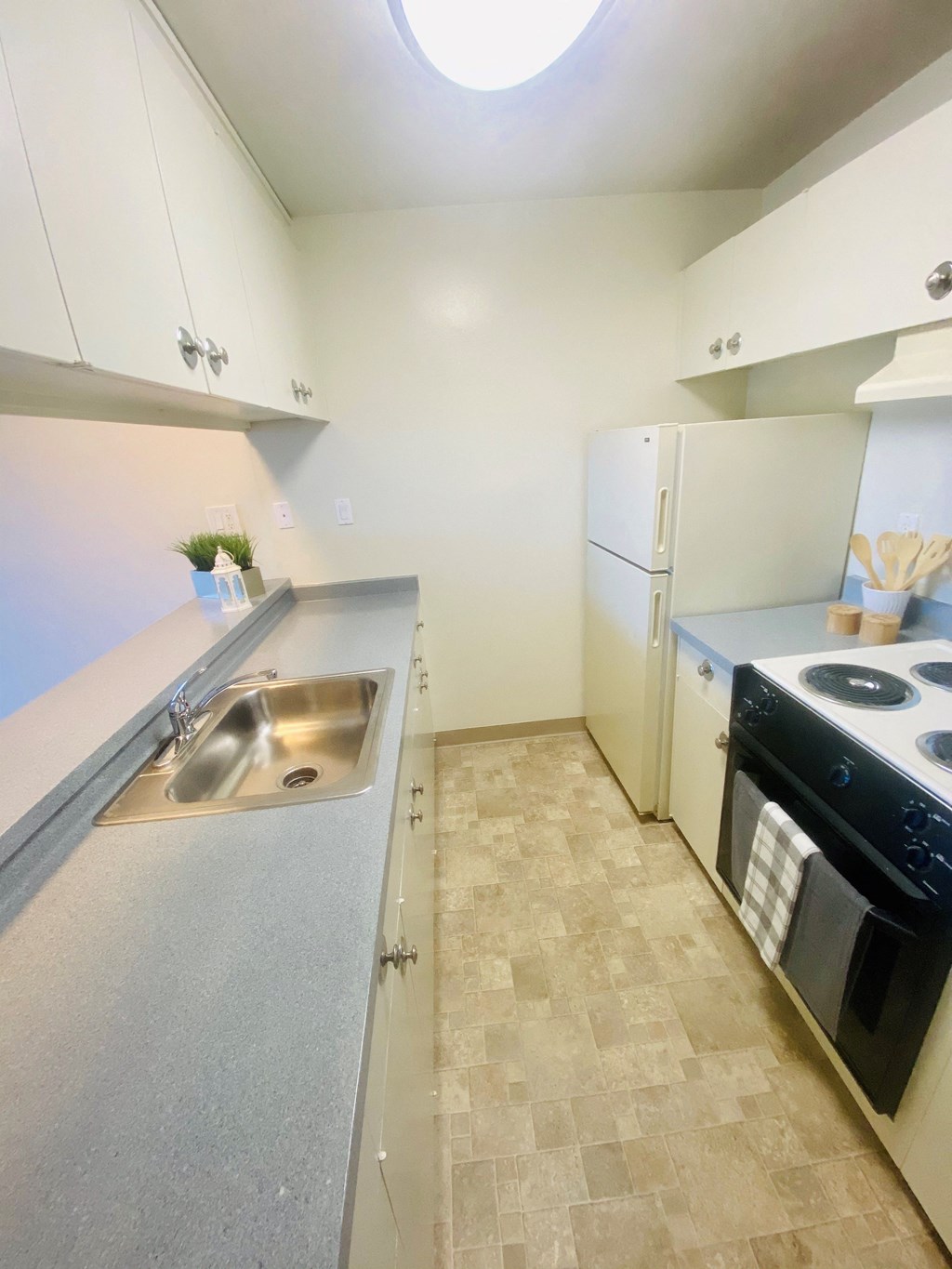A large white kitchen area with stove refrigerator and sink