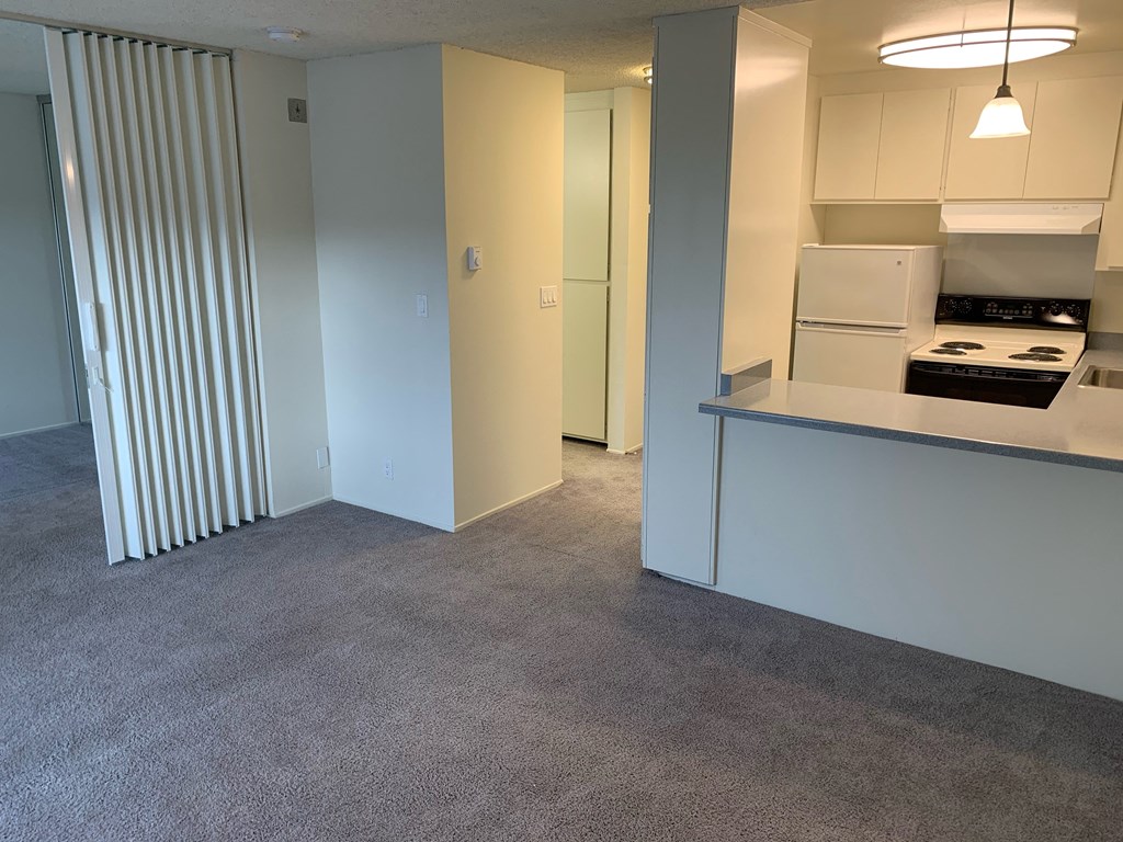 a kitchen with a stove and a refrigerator in a living room